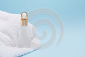 Aromatherapy or Massage Oil with white towel on blue background, copy space