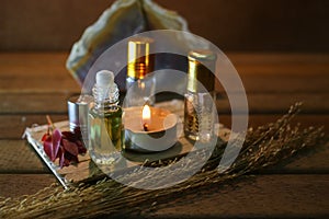 Aromatherapy oil and light candle on wood