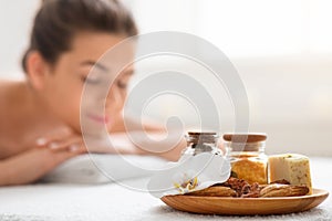 Aromatherapy plate over resting young woman on massage table