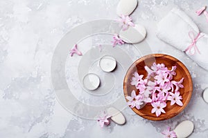 Aromatherapy, spa, beauty background with massage pebble, perfumed flowers water and candles on stone table top view. Flat lay.