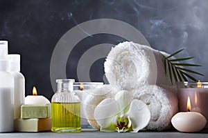 Aromatherapy, spa, beauty treatment and wellness background with massage oil, orchid flowers, towels, cosmetic products and candle