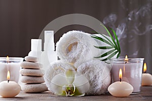 Aromatherapy, spa, beauty treatment and wellness background with massage pebbles, orchid flowers, towels, cosmetic products