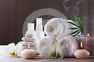 Aromatherapy, spa, beauty treatment and wellness background with massage pebbles, orchid flowers, towels, cosmetic products photo