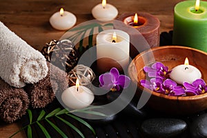 Aromatherapy, spa, beauty treatment and wellness background with massage stone, orchid flowers, towels and burning candles