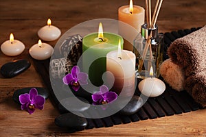 Aromatherapy, spa, beauty treatment and wellness background with massage stone, orchid flowers, towels and burning candles