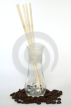 Aromatic air freshener and coffee beans on white background