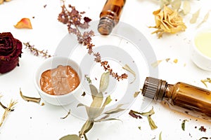 Aromatic botanical cosmetics. Dried herbs flowers mixture, facial mud clay mask, oils, applying brush. Holistic herbal skincare