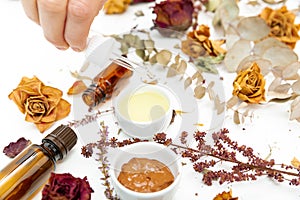 Aromatic botanical cosmetics. Dried herbs flowers mixture, facial mud clay mask, oils, applying brush. Holistic herbal skincare