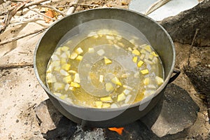 An aromatic cauldron of goatwater simmering over a wood fire in the southern caribbean