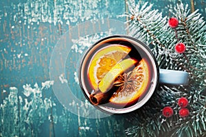 Aromatic christmas mulled wine or gluhwein with spices and orange slices on vintage teal table top view.Traditional winter drink