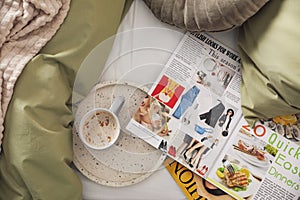 Aromatic coffee and magazines on bed with linens, flat lay