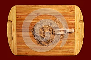 Aromatic fragrant organic spice from cumin powder, on a wooden cutting board in a wooden spoon