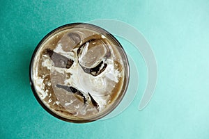 Aromatic fresh iced coffee on a green background.