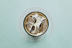 Aromatic fresh iced coffee on a green background.