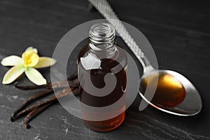 Aromatic homemade vanilla extract on table, closeup