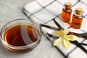 Aromatic homemade vanilla extract on light grey table