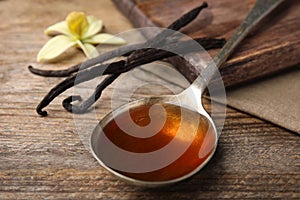 Aromatic homemade vanilla extract on table, closeup photo