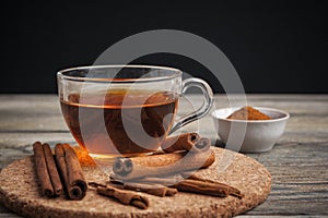 Aromatic hot cinnamon tea on wooden table