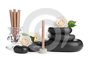 Aromatic incense sticks, roses and spa stones on white background