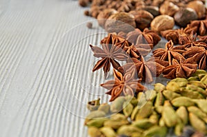 Aromatic Indian spices on the gray kitchen table: star anise, nutmeg, cardamom close up. Spices texture background with copy space