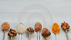 Aromatic Indian spices and herbs on metal spoons: star anise, fragrant pepper, cinnamon, asafoetida, turmeric. Spices texture