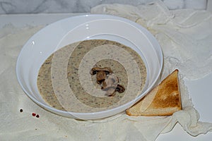 Aromatic mushroom cream soup with champignons. Fresh vegetables and freshly baked bread. A hearty and delicious lunch.