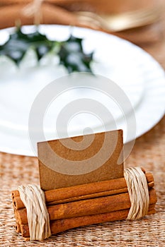 Aromatic place card with holly twig in white plate