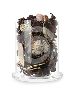 Aromatic potpourri of dried flowers in glass jar on background