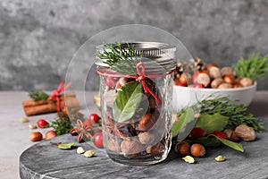 Aromatic potpourri in glass jar on grey table