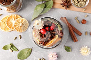Aromatic potpourri in glass jar on light table, flat lay