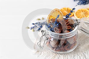 Aromatic potpourri in glass jar on white table, closeup. Space for text