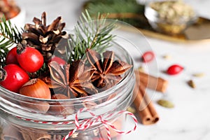 Aromatic potpourri in glass jar on white table, closeup. Space for text