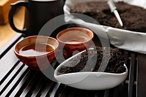 Aromatic pu-erh on wooden tray, closeup. Fermented tea