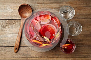 Aromatic punch drink with citrus fruits on wooden table, flat lay