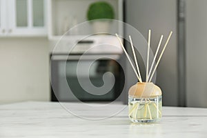 Aromatic reed air freshener on marble table indoors. Space for text