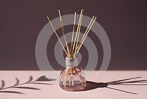 Aromatic reed air freshener on pink background hard shadow. Aromatherapy sticks. Air refresher bottle