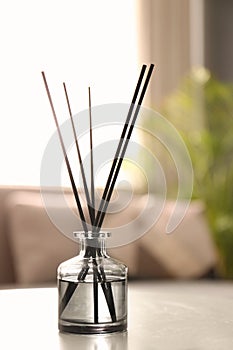 Aromatic reed air freshener on white table in room