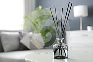 Aromatic reed air freshener on white table in room. Space for text