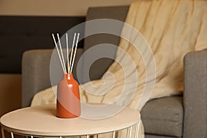 Aromatic reed air freshener on wooden table indoors, space for text