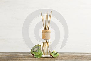 Aromatic reed freshener and kiwi on wooden table