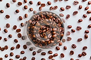 Aromatic roasted coffee beans scattered on a white background