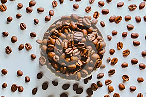 Aromatic roasted coffee beans scattered on a white background