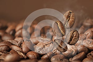 Aromatic roasted coffee beans and steam, closeup