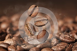 Aromatic roasted coffee beans and steam, closeup