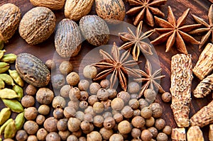 Aromatic spices on a dark plate - star anise, fragrant pepper, calamus root, cinnamon, nutmeg close up. Spices texture background