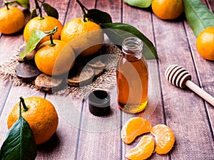 Aromatic tangerine oil, with tangerines on a wooden background, selective focus