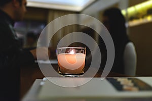 Aromatized candle in a glass cup at the reception