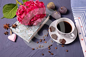 Aromaton coffee, book and pink hydrangea pieces of dark chocolate on a saucer