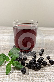 Aronia Berry Juice and mint on wooden table