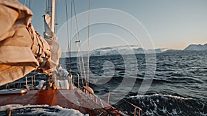 Around the world Arctic yacht goes along the northern cold waves. Swinging and chopping polar ridges of water. Exclusive